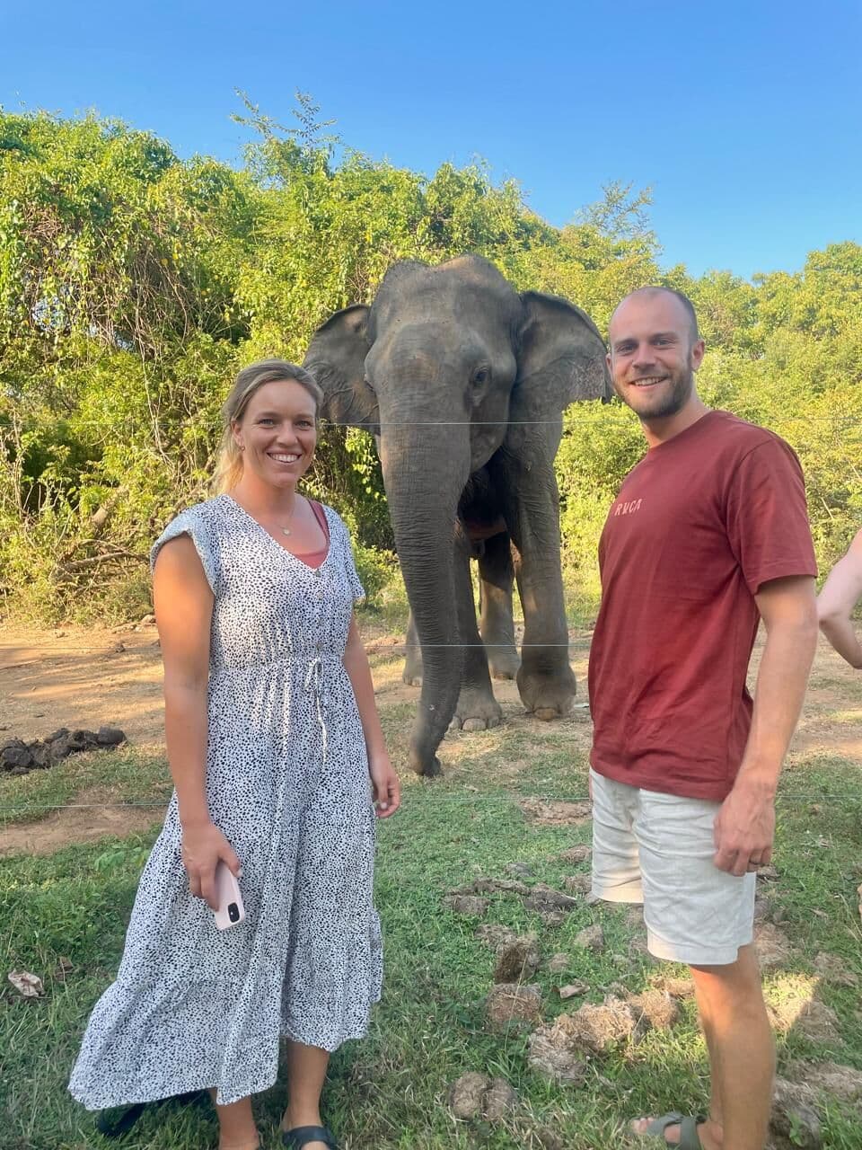 Two guests posing with an elephant