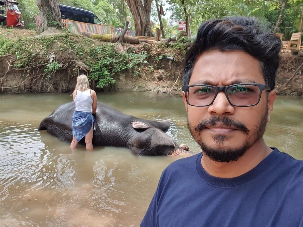 Elephant bathing in the river with a guest