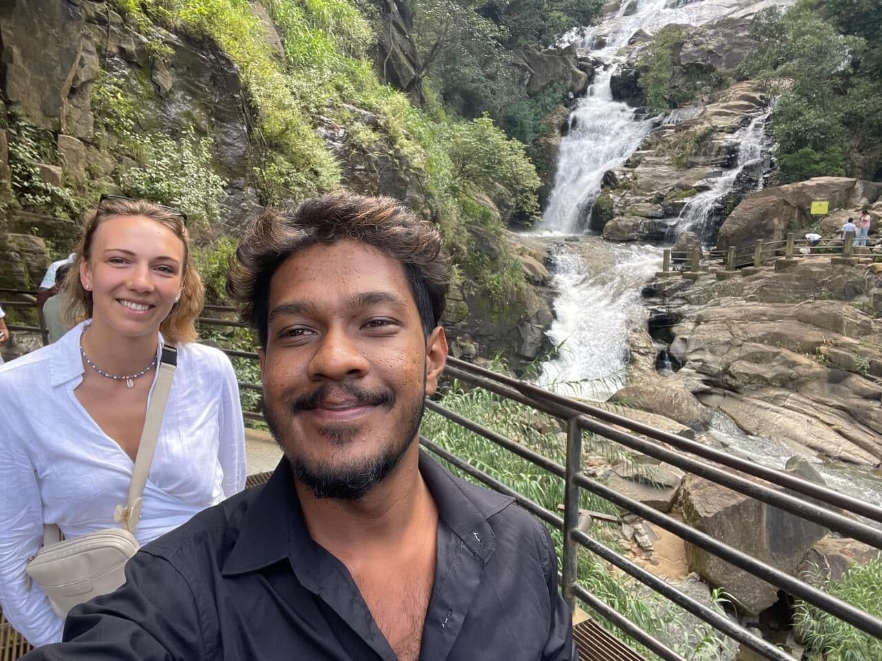 Our guide beside a cascading waterfall