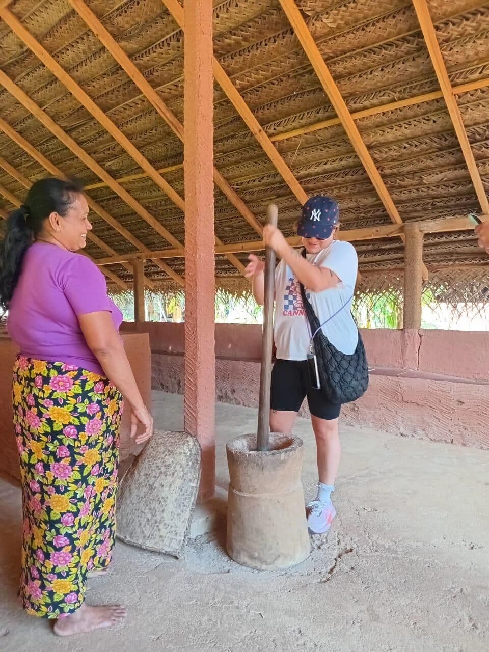 Guest pounding rice in a traditional village