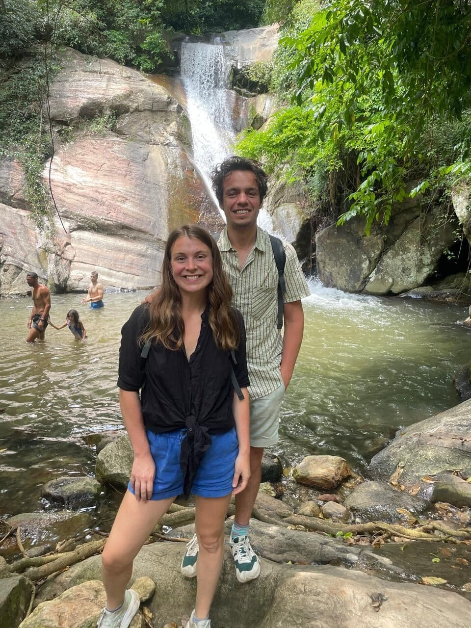 Guests at a waterfall with a natural pool